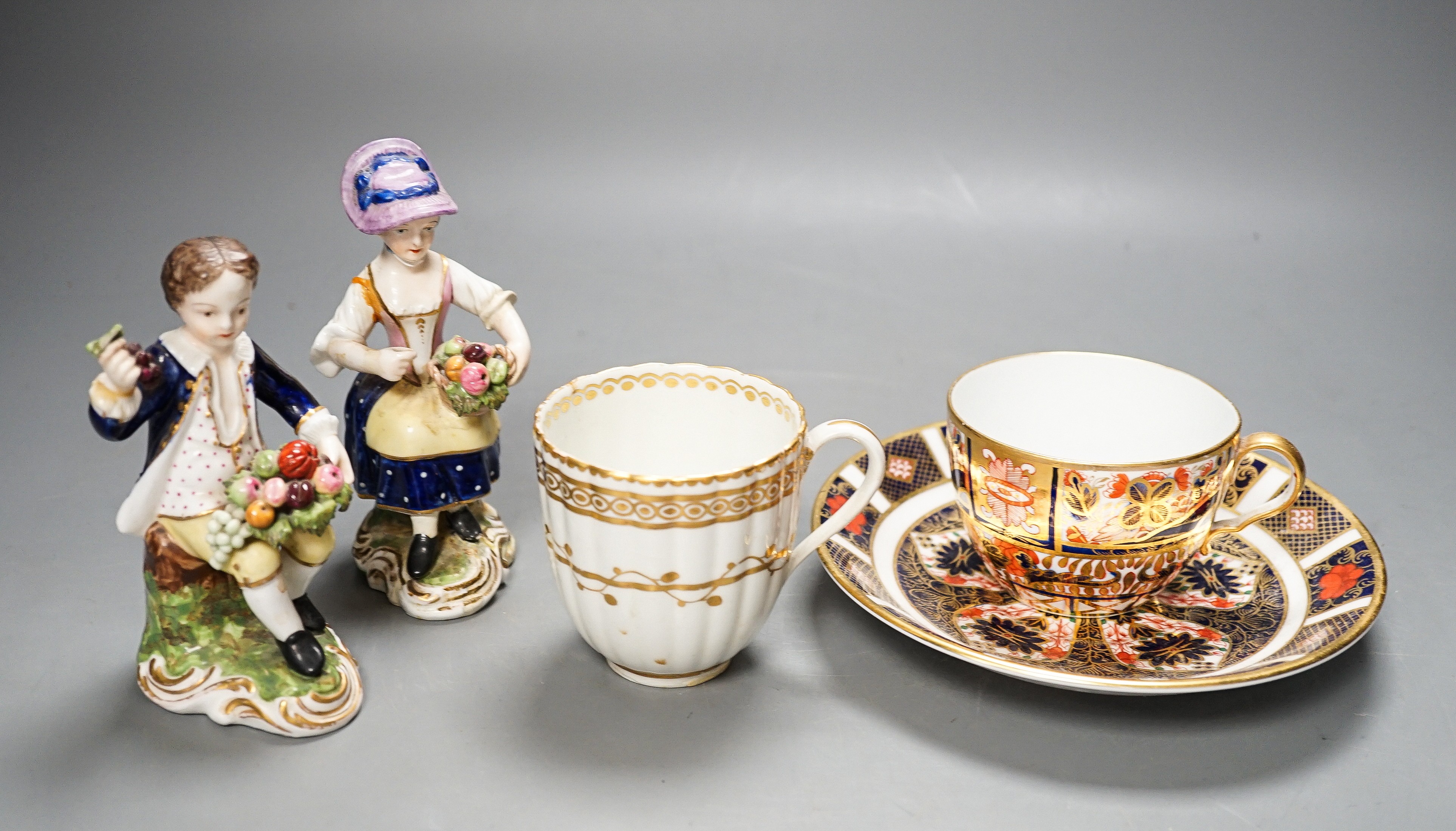 A Derby Imari saucer, a similar tea cup, a pair of Sampson Hancock, Derby figures, and a Derby cup, tallest figure 13 cms high.